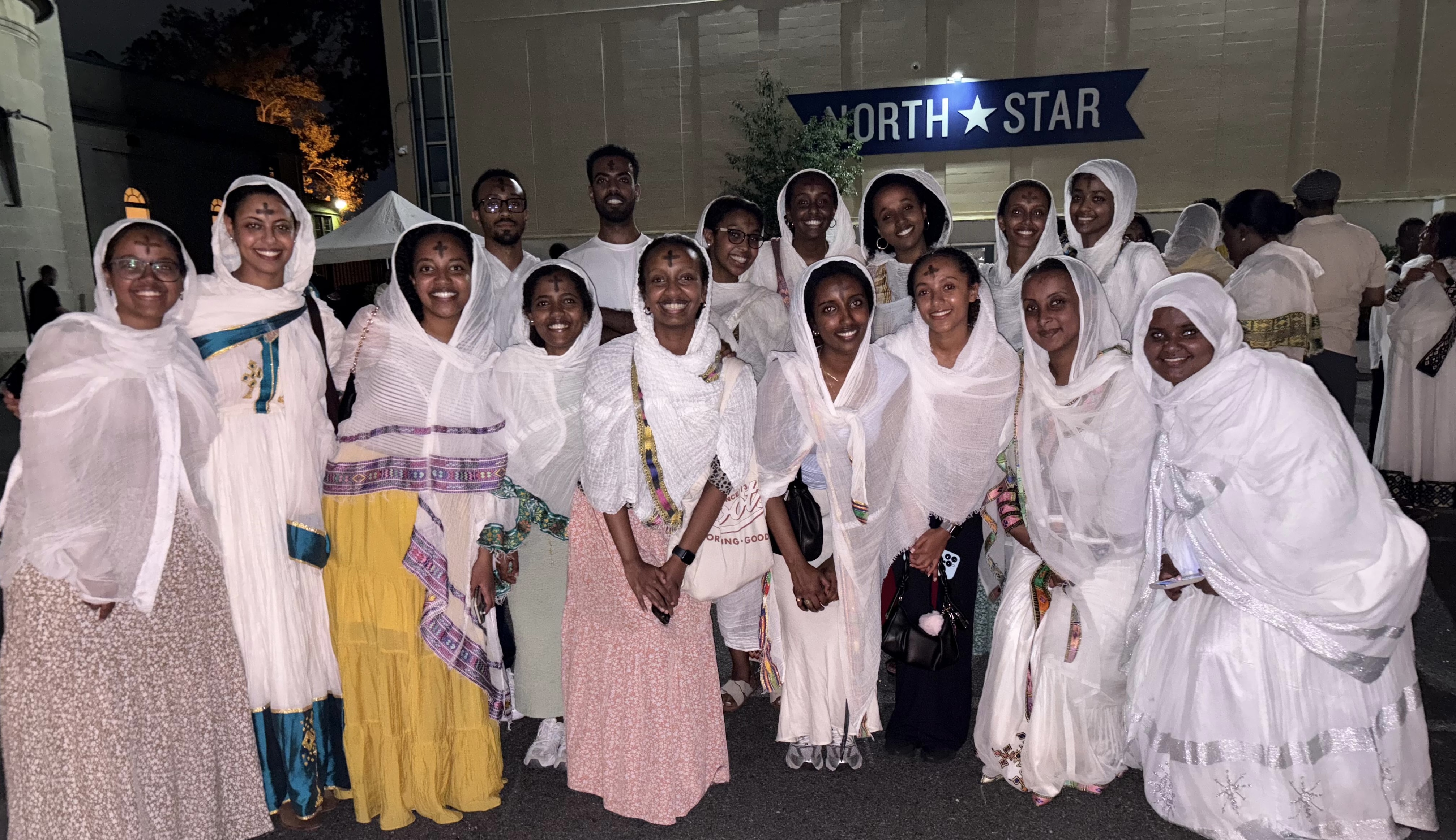 OTY NYC members celebrate Meskel together at night, marked with ash crosses